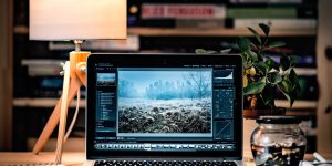Computador portátil sobre un escritorio con lámpara y libros, fotografía temática de archivo de 2016